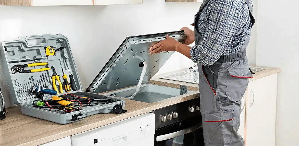 Handyman repairing a cooktop and checking wiring connections in Atlanta, GA