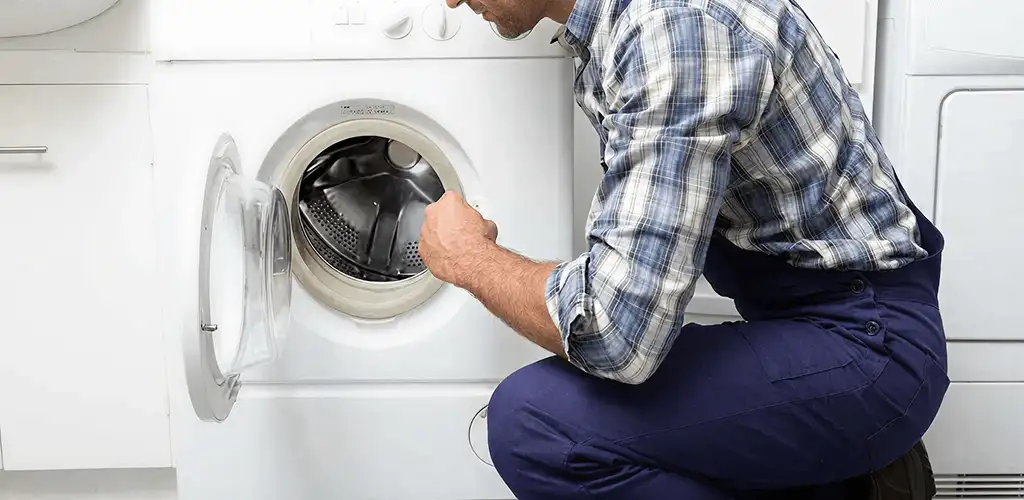 Handyman inspecting a dryer drum and internal parts for repair in Atlanta, GA