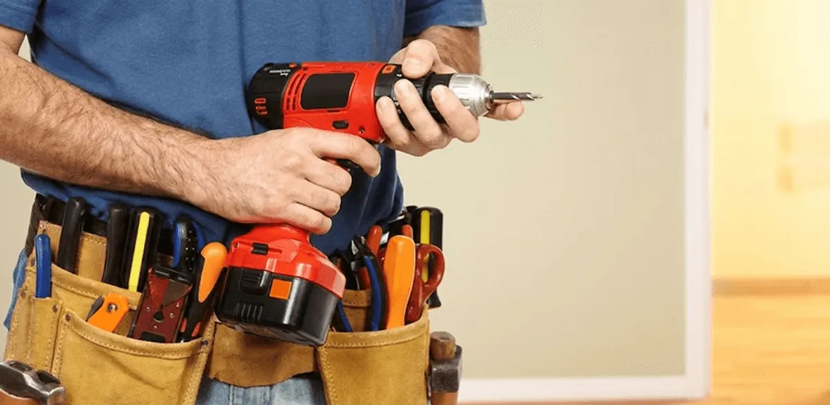 Handyman holding a power drill for home repairs and installations in Atlanta, GA
