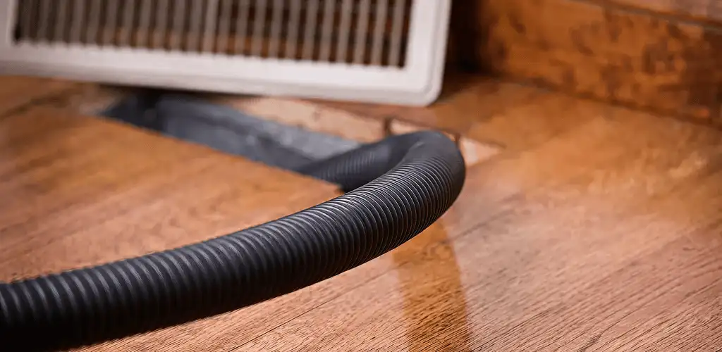 Air duct cleaning hose inserted into a floor vent for ductwork cleaning in Atlanta, GA